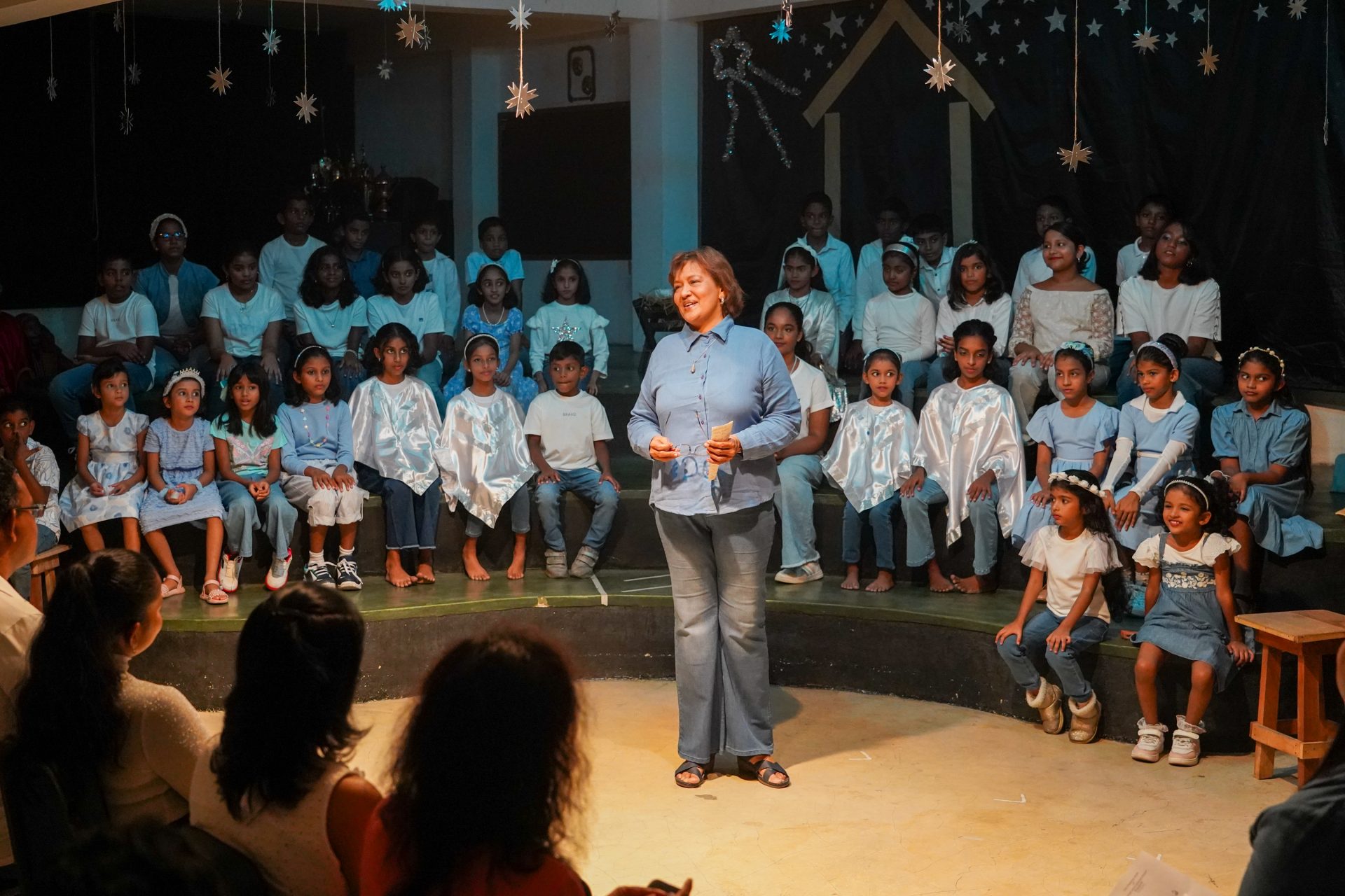 Community school play scene with children in costumes and engaging narrator.