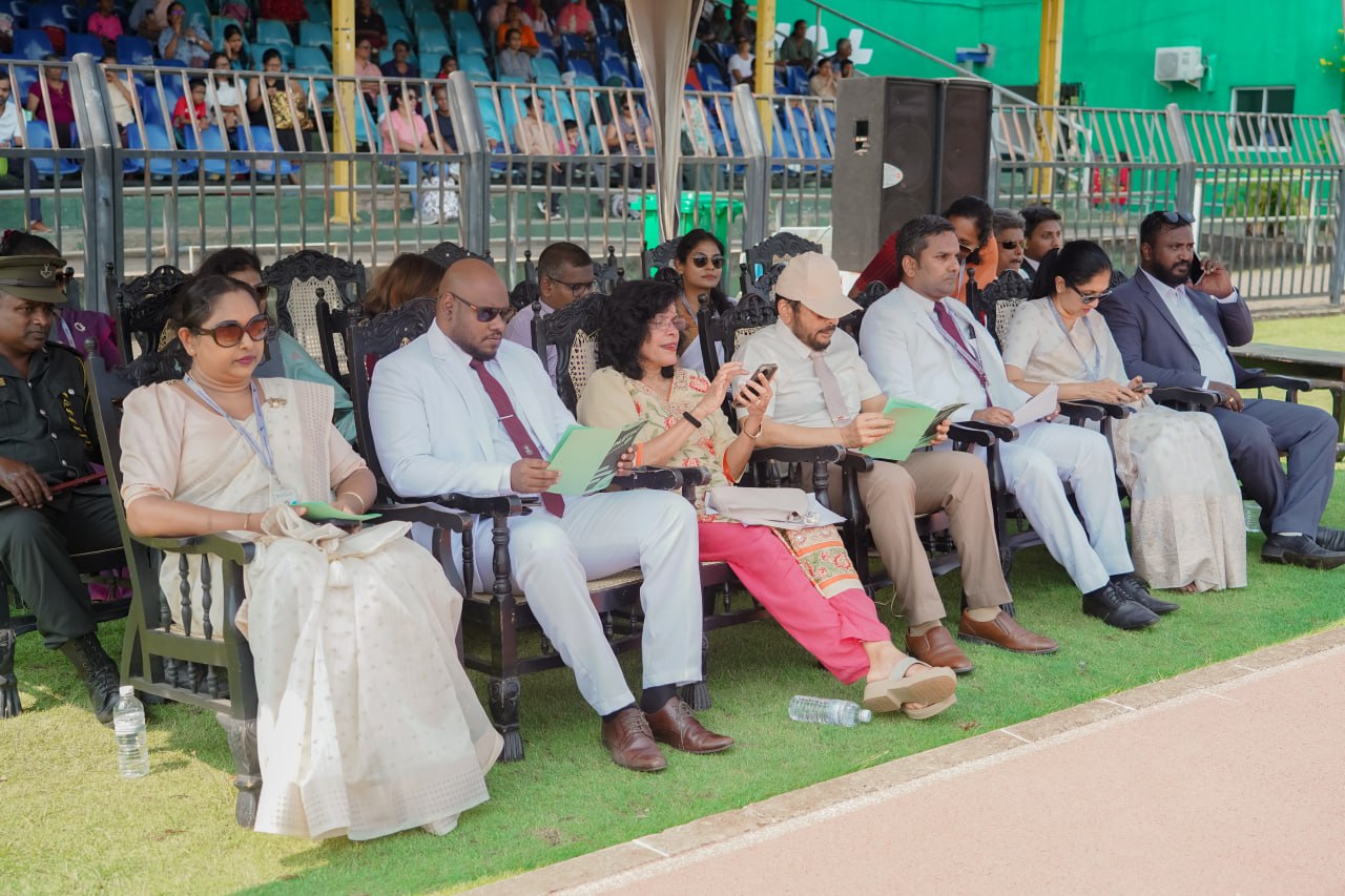 Outdoor event with diverse officials in traditional and formal attire, stadium background.