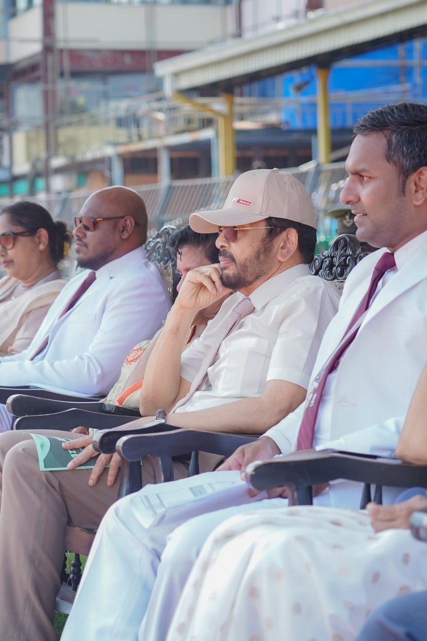 Formal event with attendees in white attire amid evolving urban backdrop.
