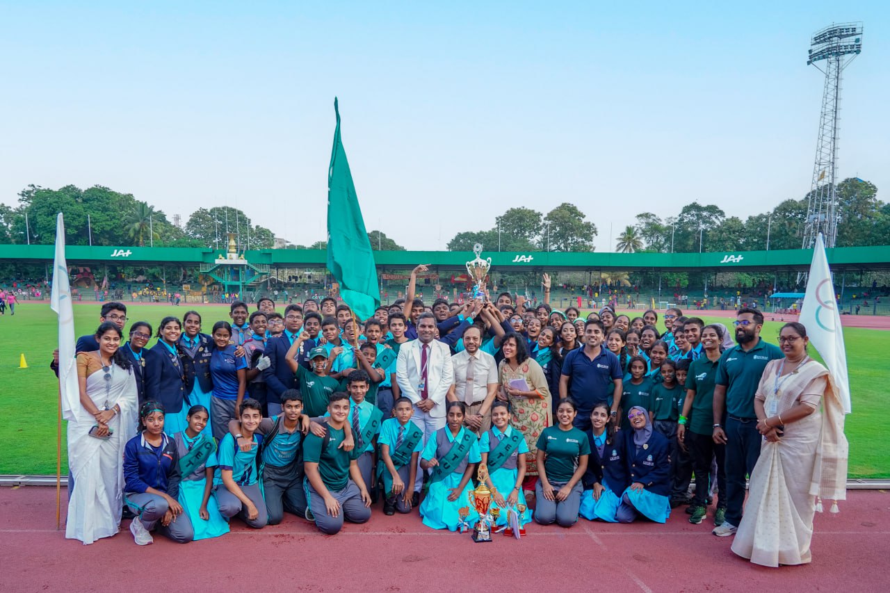 Diverse team celebrates sports victory with trophy and flags on a sunny stadium day.