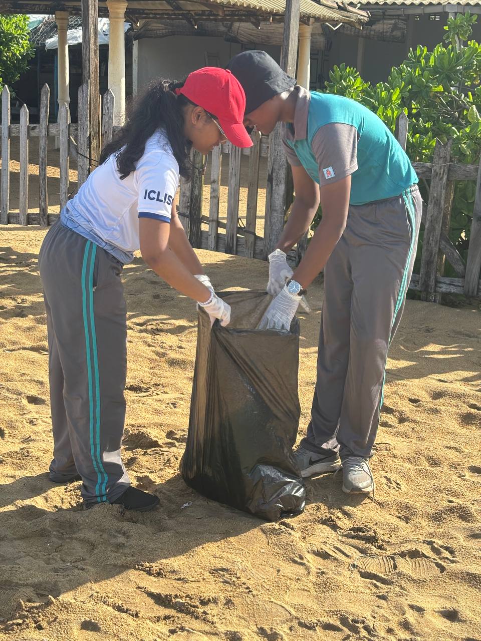 Volunteers collect beach trash in bags, emphasizing environmental conservation and community effort.