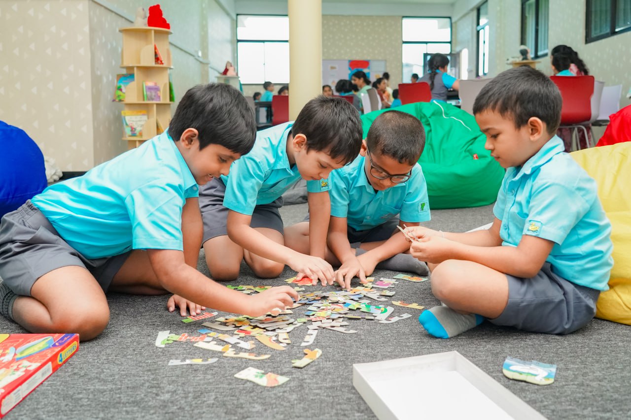 Children Engaged in Puzzle Solving Activity Kids in blue uniforms solving a jigsaw puzzle in a bright classroom.
