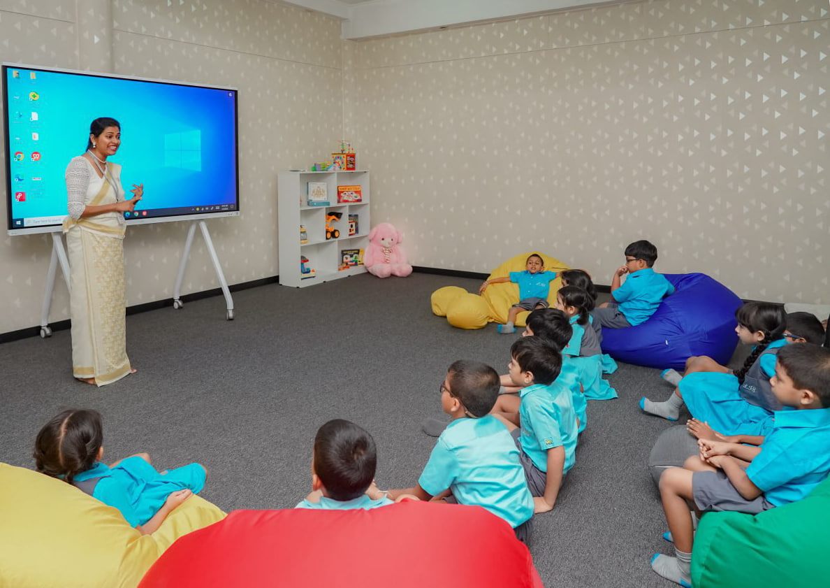 Modern Learning: Bean Bags and Interactive Teaching Modern classroom: teacher engages students with interactive screen and colorful bean bags.