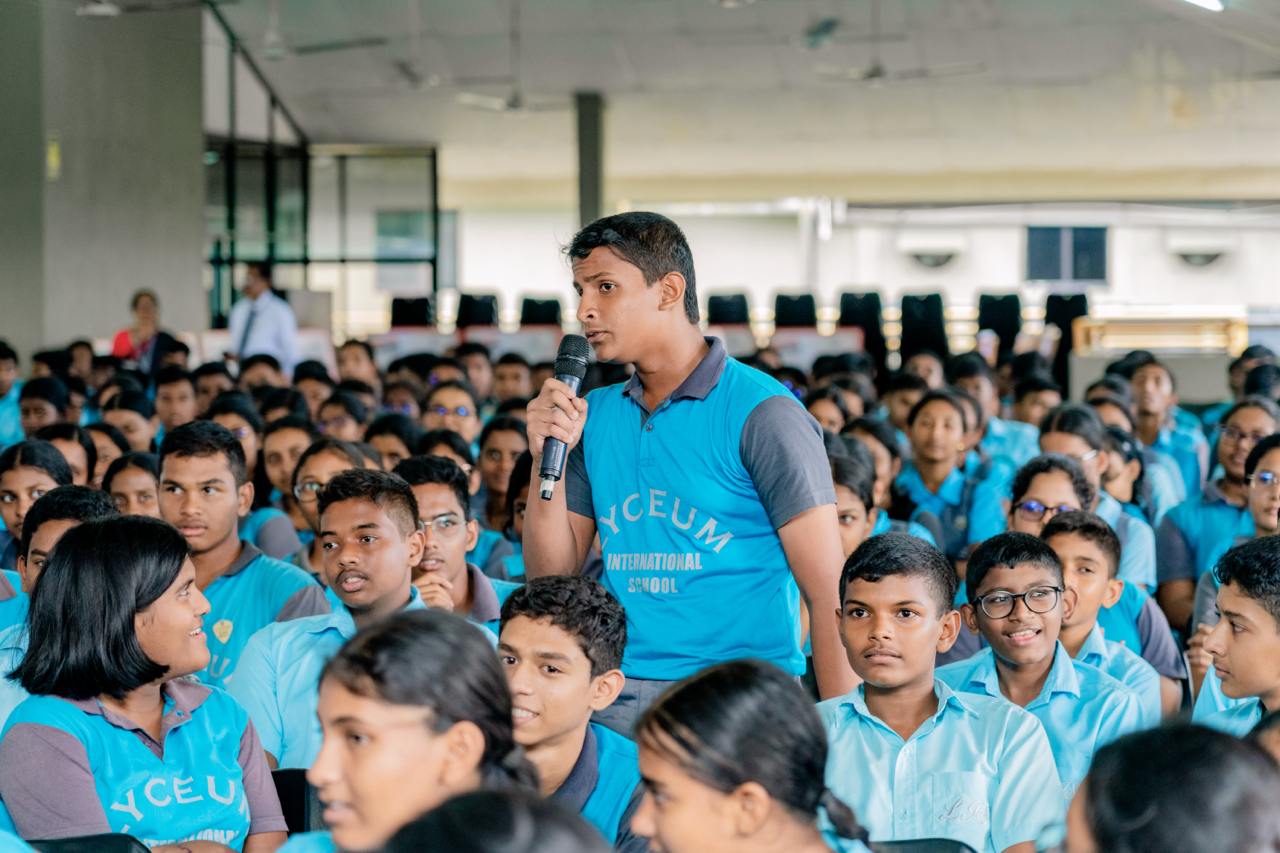Students engage in a lively school assembly, promoting interactive learning and participation.