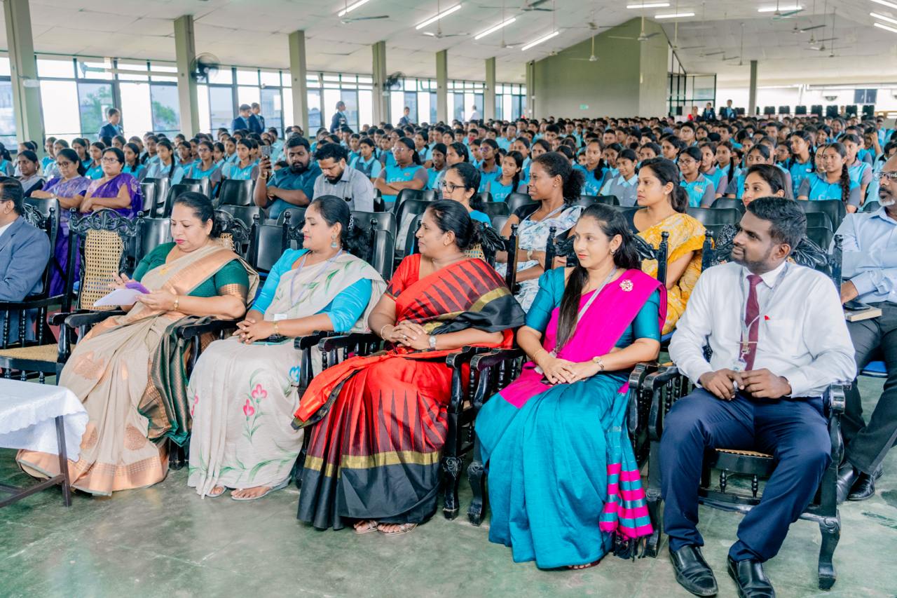 Formal event with colorful sarees and uniforms, highlighting cultural unity and diversity.