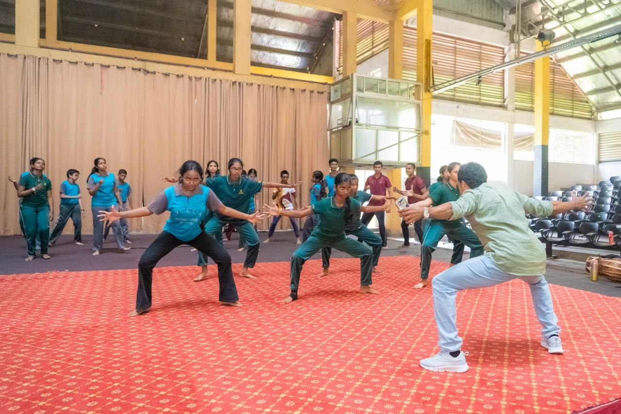 Group fitness class on vibrant carpet in sunlit hall with high ceilings.