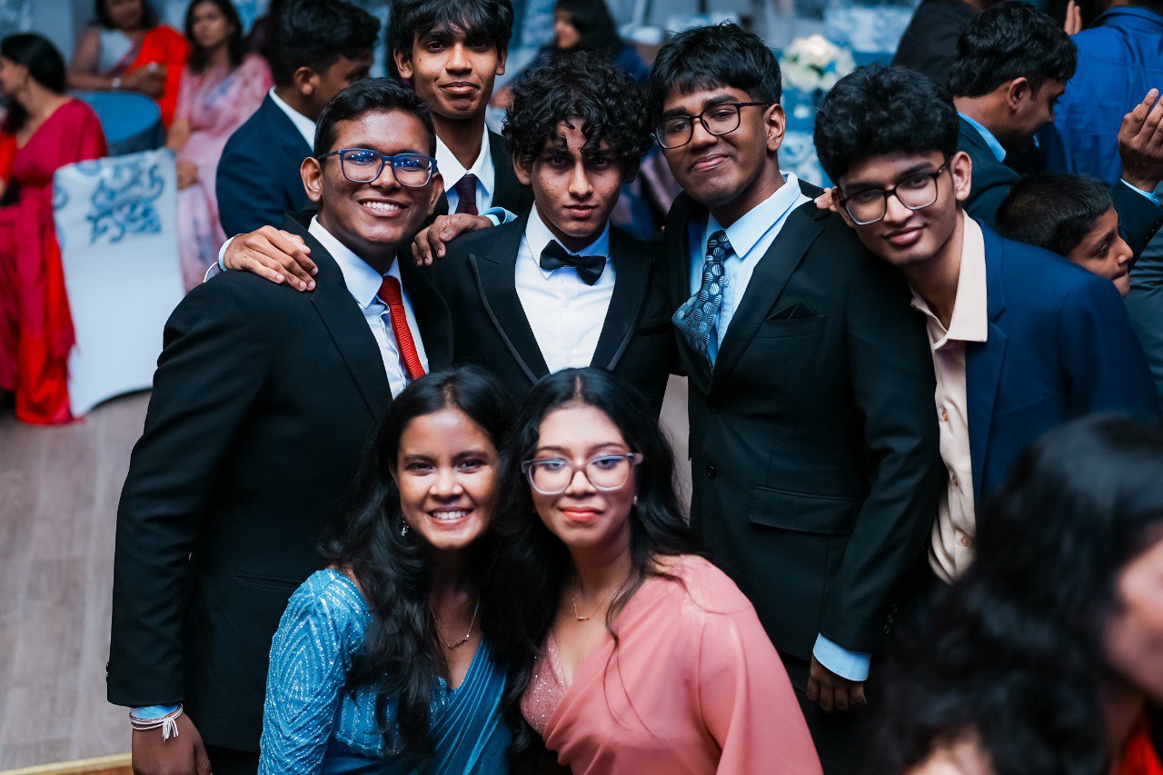 Friends Celebrating in Formal Attire at Prom Night Group of young adults in formal attire posing at prom or graduation party celebration.