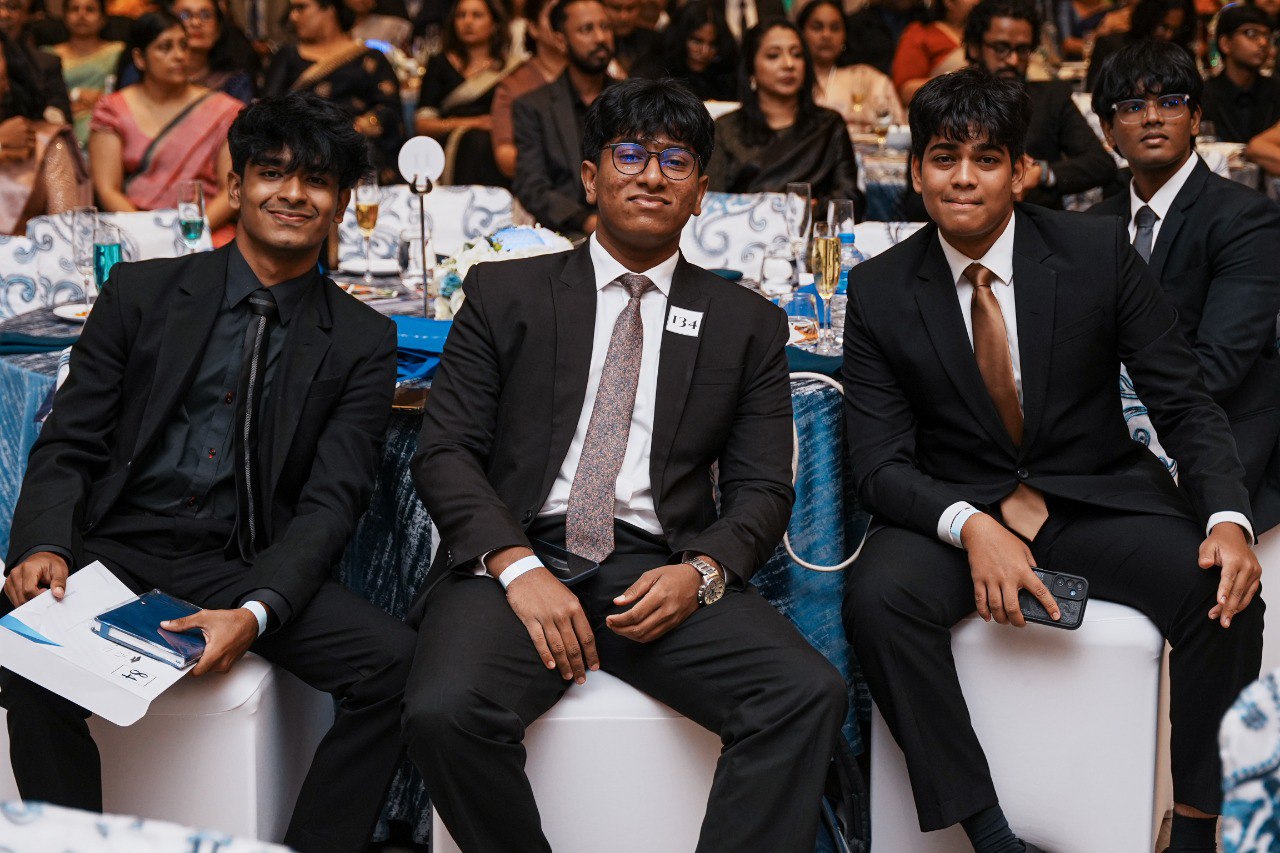 Young Men in Suits at Elegant Formal Event Young men in black suits at formal event, graduation or awards ceremony, elegant decorated venue.