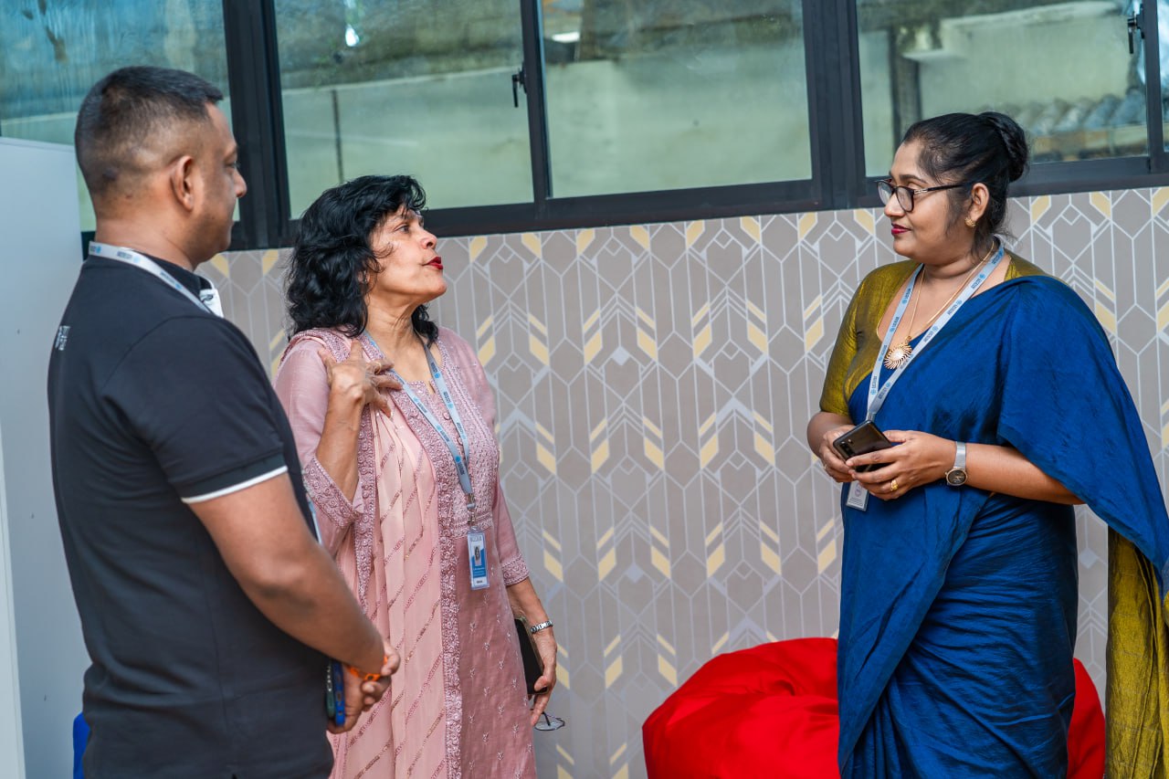 Colleagues having a professional discussion in a modern office lounge with vibrant decor.