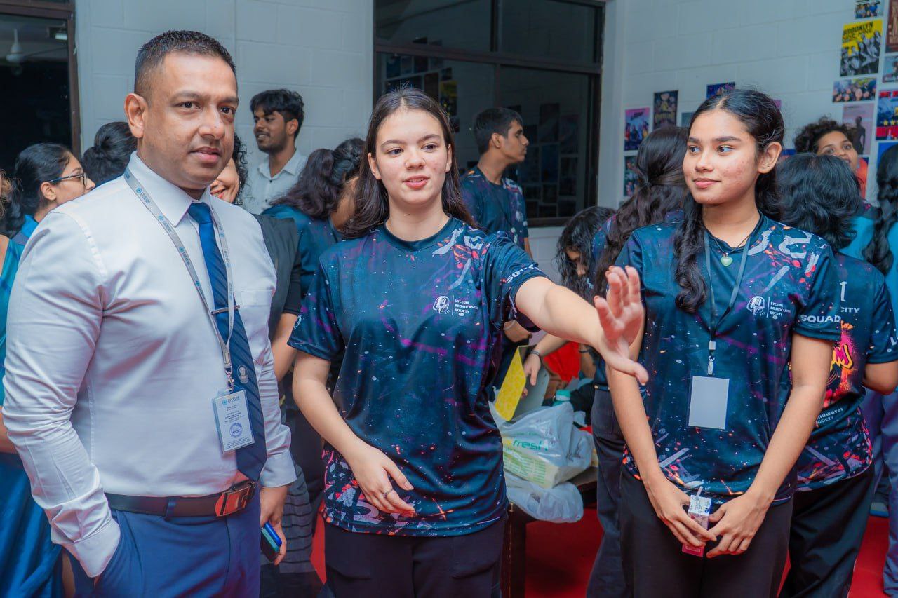 Students and faculty at a lively university event, engaging in discussion and team activities indoors.