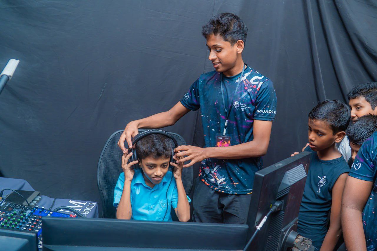 Kids at a technology workshop, learning computer gaming with mentor guidance and teamwork.