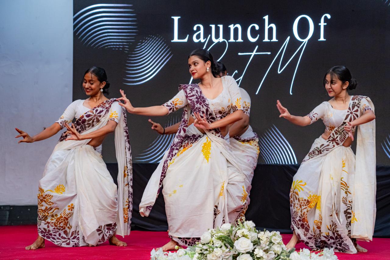 Indian classical dancers performing in sarees on stage at BTM launch cultural event.