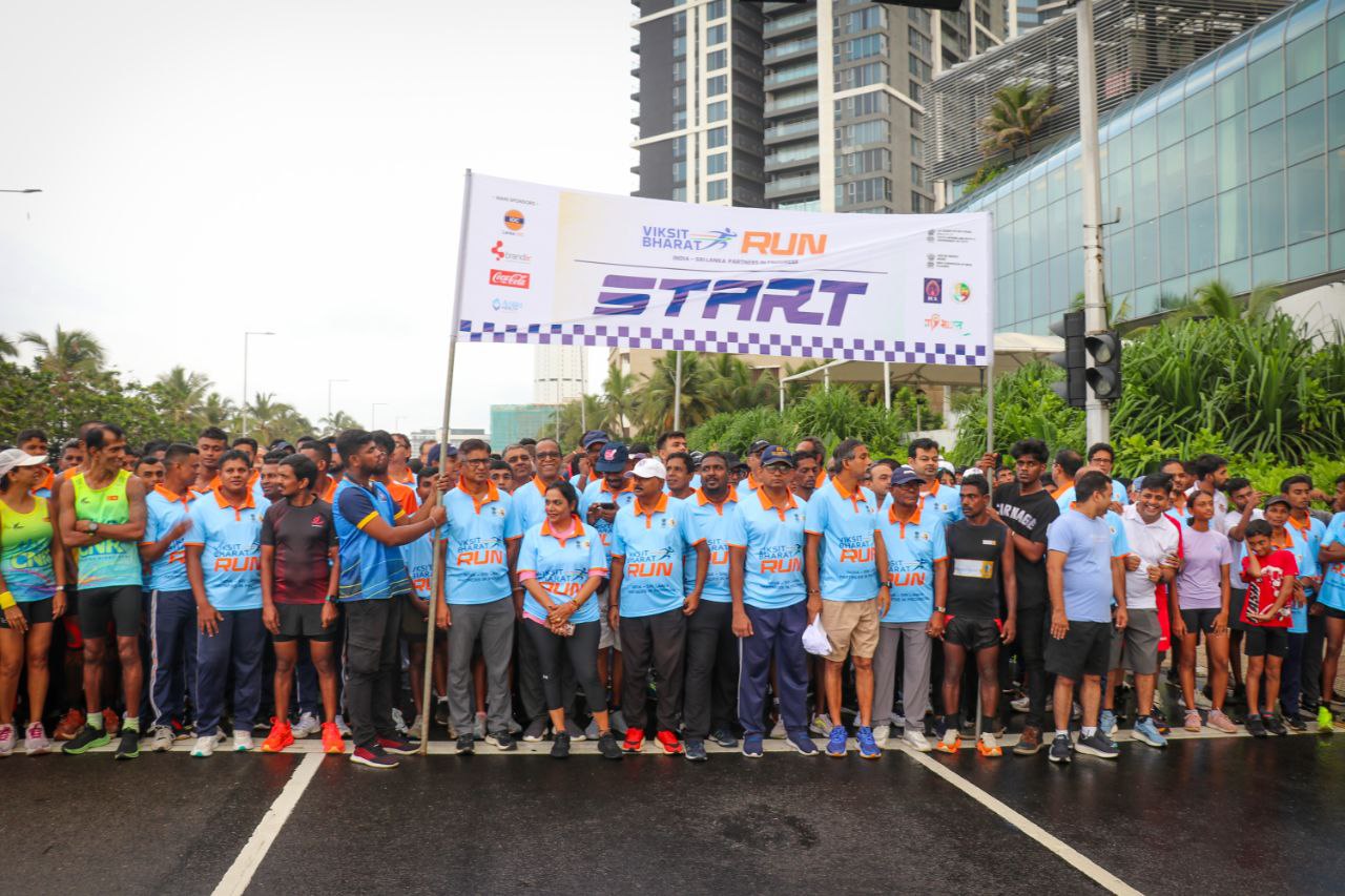 Viksit Bharat Run participants at starting line, community marathon event, urban city, blue shirts.