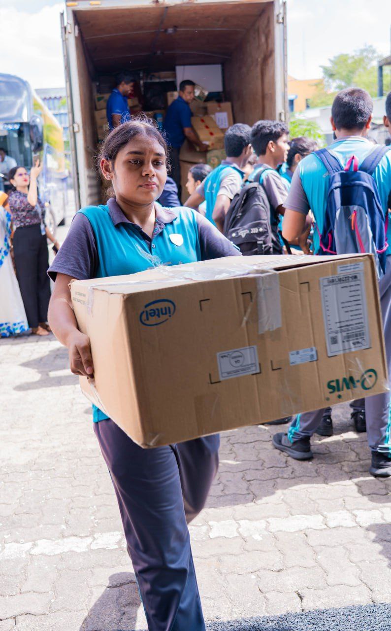 Volunteers in blue uniforms unload Intel boxes from a truck during a community service event.