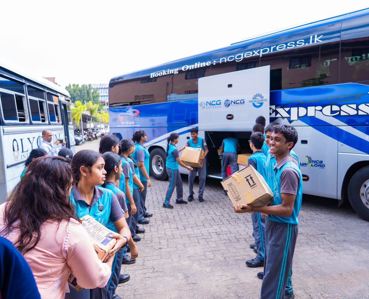 School children in uniforms unloading donation boxes from buses during a community service event.