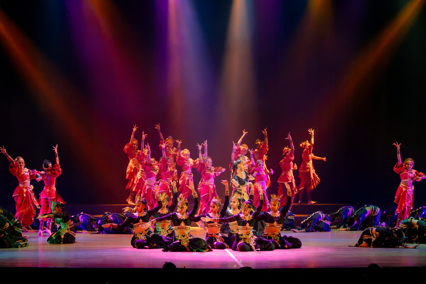 Spectacular Cultural Dance Performance With Vibrant Costumes Dancers in colorful traditional costumes perform a vibrant, synchronized cultural dance on a lit stage.