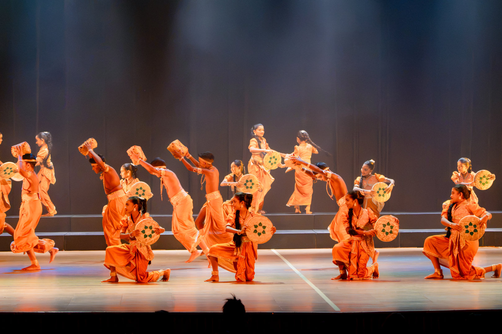 Vibrant Indian Folk Dance With Traditional Bamboo Props Young dancers in traditional Indian costumes performing folk dance on stage with decorative bamboo props.