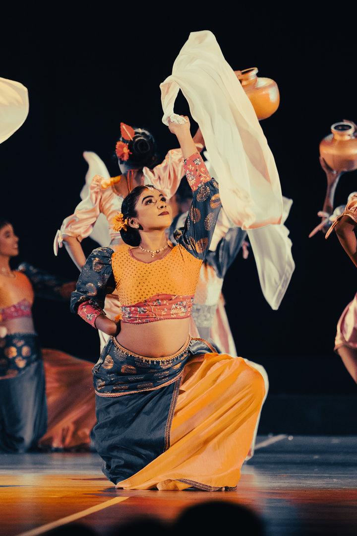 Vibrant Indian Folk Dance With Colorful Costumes and Pots Indian folk dancers in colorful costumes perform with pots and scarves under dramatic stage lighting.