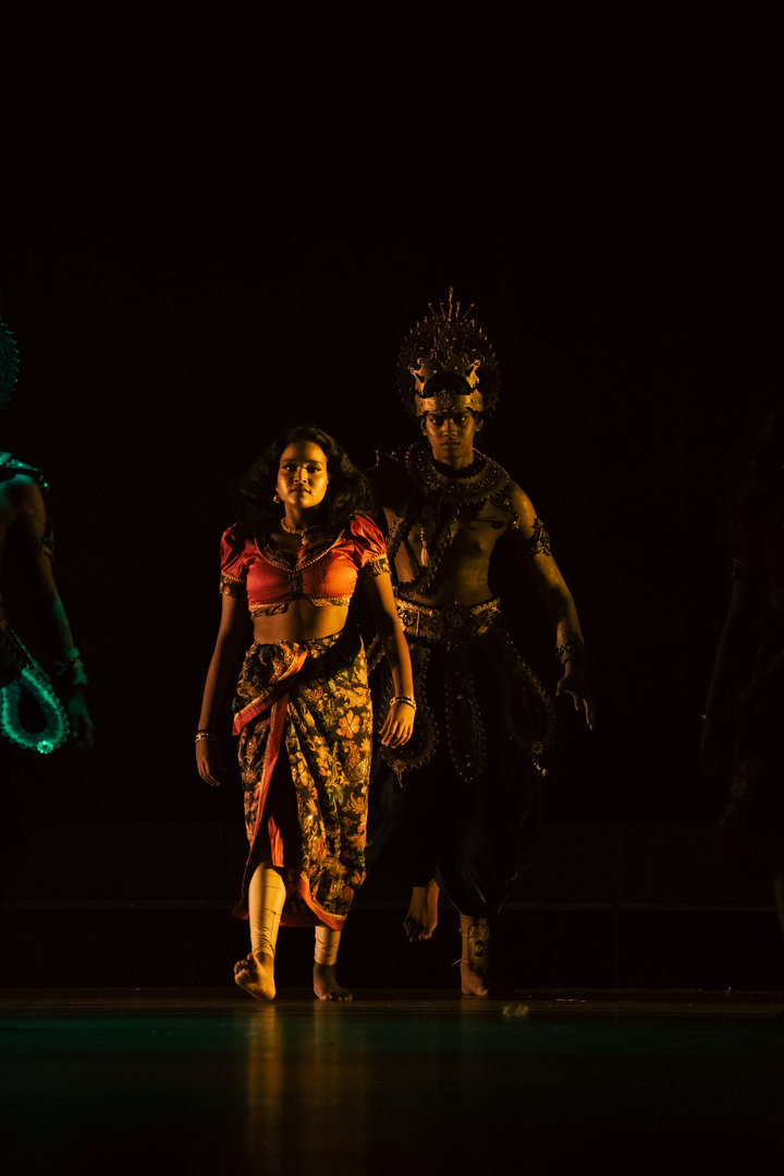 Mythical Indian Stage Performance Under Dramatic Spotlight Indian mythological stage performance with costumed man and woman in dramatic lighting and traditional attire.