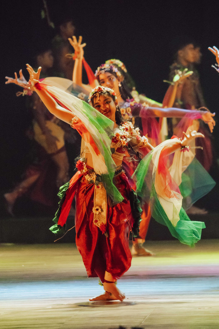 Vibrant Folk Dance Performance in Colorful Traditional Costumes Dancers in vibrant traditional costumes perform an expressive folk dance on a warmly lit stage.