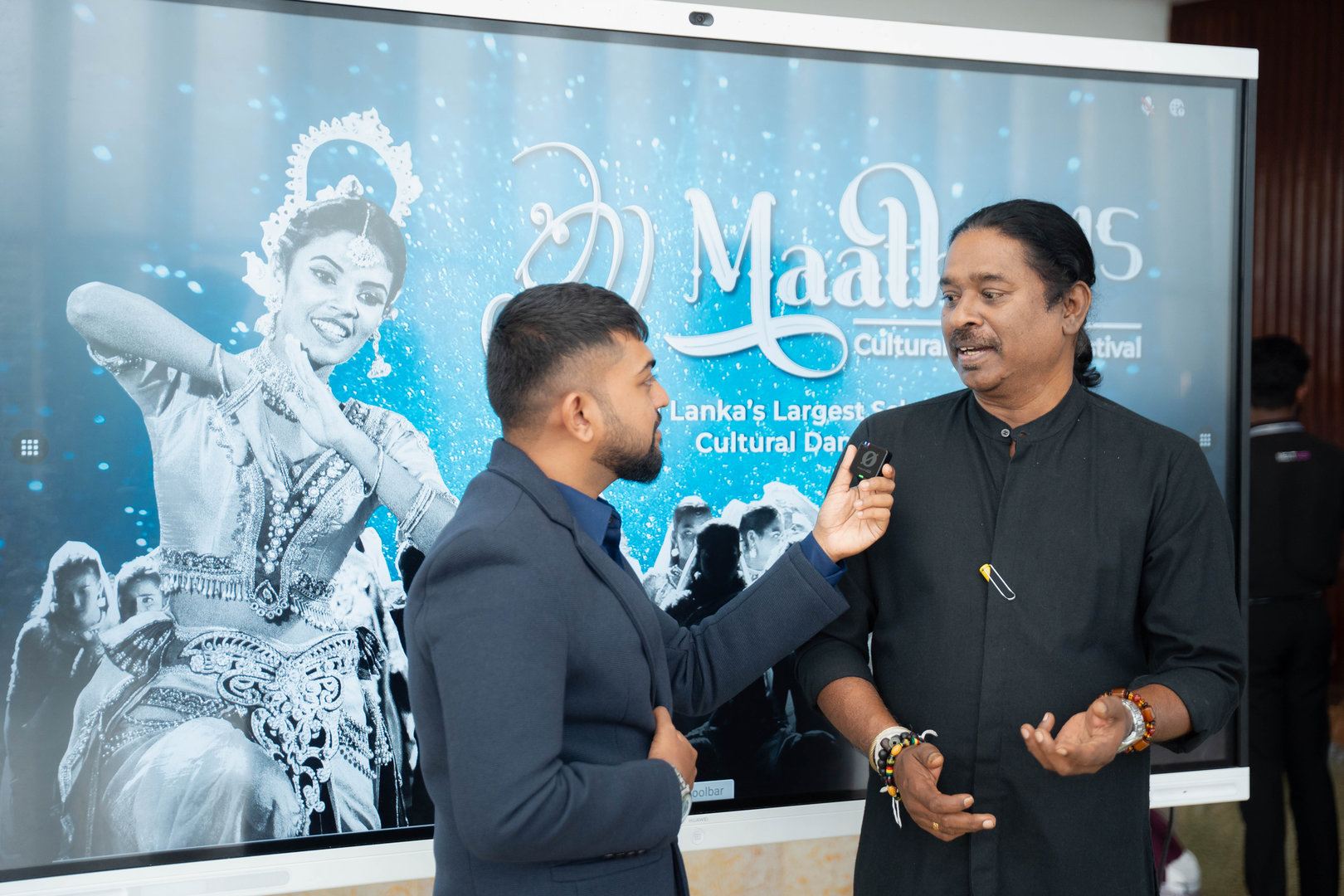 Live Interview at Sri Lankan Cultural Dance Festival Interview at Sri Lankan cultural festival with classical dancer and colorful event backdrop.