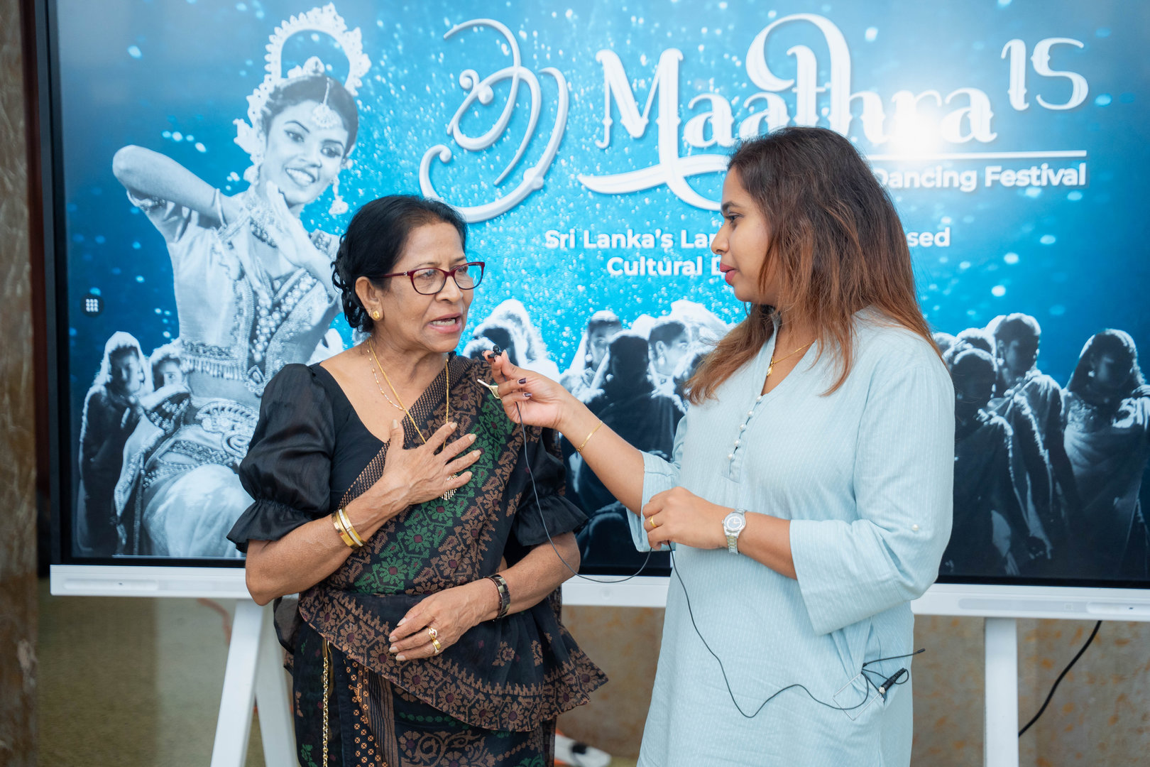 Generations Unite at Maathra 15 Sri Lankan Dance Festival Elderly Sri Lankan dancer interviewed by reporter at Maathra 15 traditional dance festival.