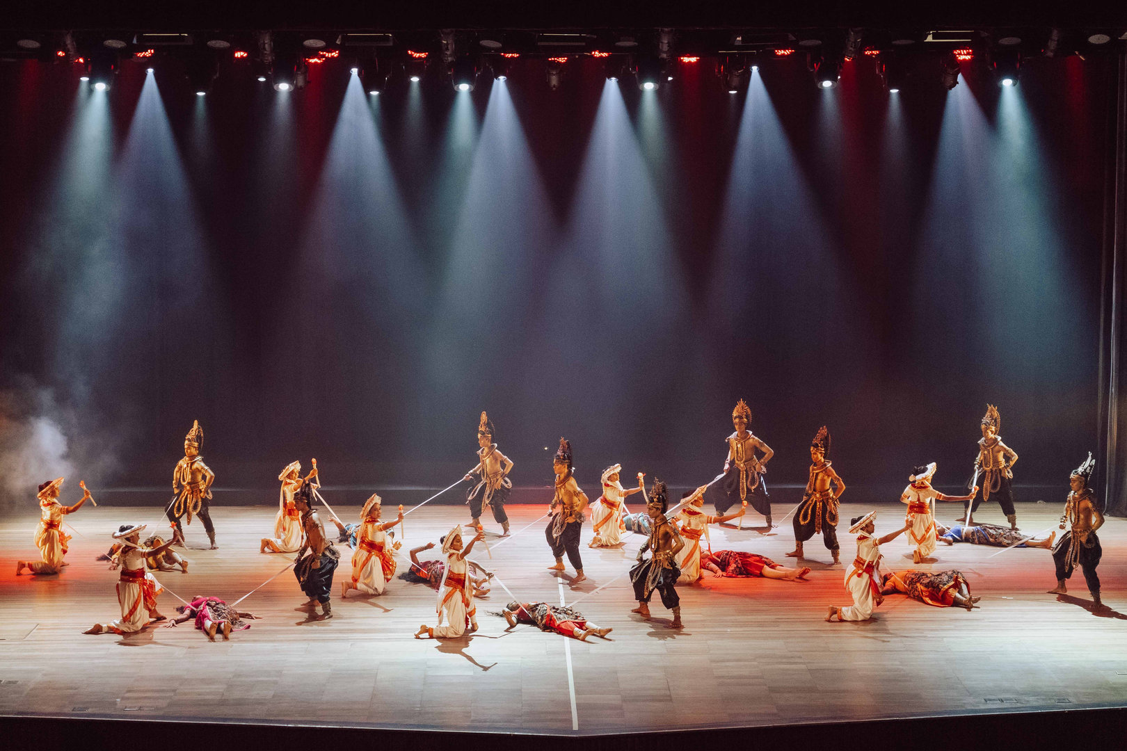 Epic Folklore Dance Performance With Vibrant Costumes and Lighting Vibrant folklore dancers in ornate costumes performing dramatic choreography on a dimly lit, theatrical stage.
